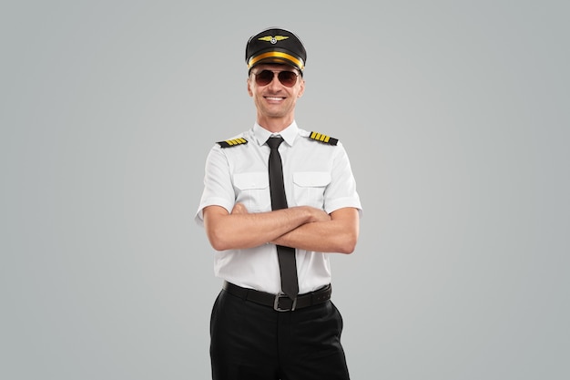 Selbstbewusster flieger in uniform mit verschränkten armen