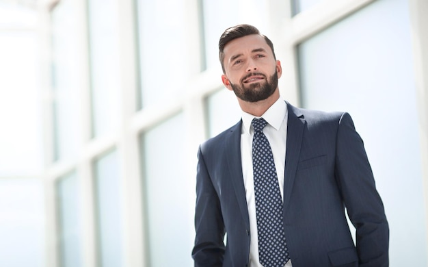 Selbstbewusster Geschäftsmann, der in einem hellen Büro steht