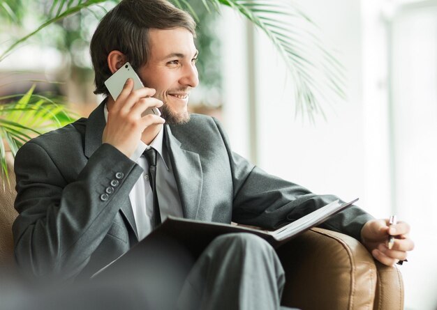 Selbstbewusster Geschäftsmann im Büro am Telefon