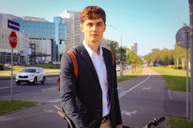 Selbstbewusster junger Geschäftsmann, der mit dem Fahrrad auf der Straße in der Stadt spazieren geht