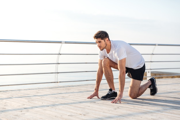 Selbstbewusster junger Sportler ist morgens laufbereit