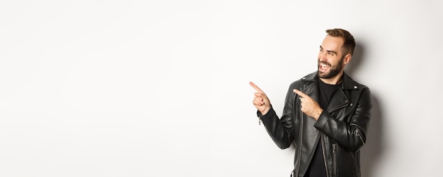 Selbstbewusster Macho-Mann in schwarzer Lederjacke, der mit dem Finger nach links auf das Promo-Angebot zeigt und das Logo weiß zeigt