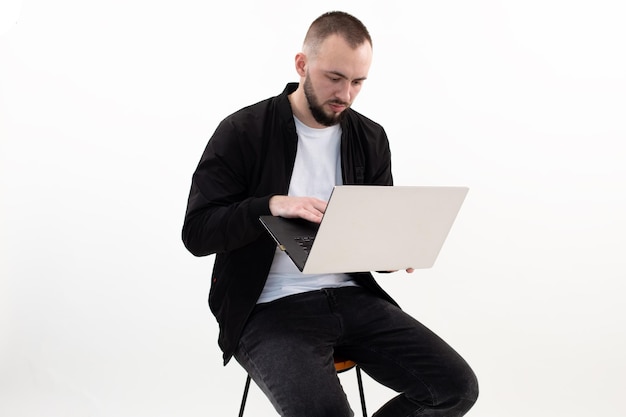 Selbstbewusster Mann mit Bart mit Laptop, der online arbeitet Erfolgreicher Geschäftsmann im Studio Online- und Remote-Job im Innenbereich