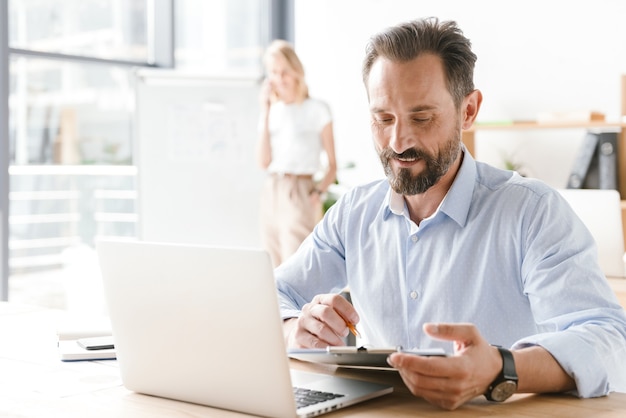 Selbstbewusster Mannmanager, der am Laptop arbeitet