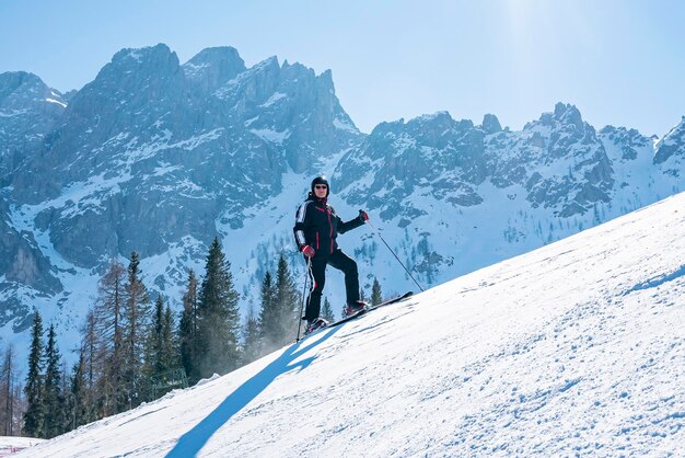 Selbstbewusster Skifahrer, der an sonnigen Tagen auf schneebedeckten Bergen Ski fährt