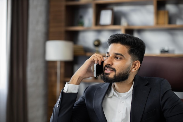 Selbstbewusster Teamleiter, der Beratungen mit Telefon im modernen Firmenbüro gibt