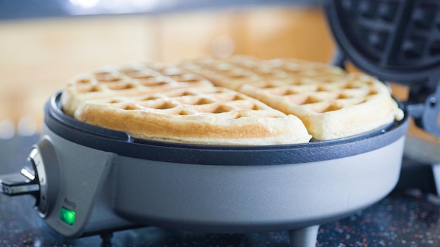 Selbstgemachte Waffeln in einem elektrischen Waffeleisen zubereiten.