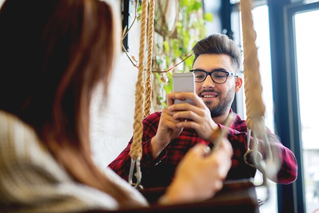 Selbstporträt machen am Restaurantpaar, das zusammen genießt. Fotomobil posiert für soziale Netzwerke.