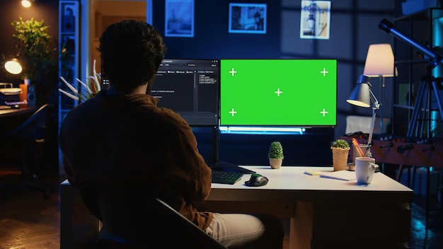 Selbstständiger, der IT-Unterstützungsaufgaben auf einem PC mit grünem Bildschirm programmiert