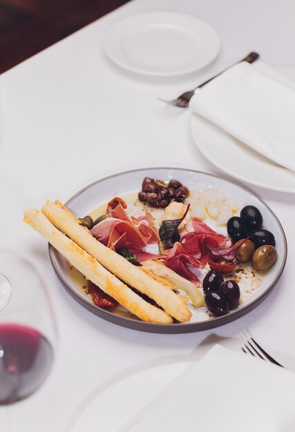 Seleção de aperitivos de carne Salami prosciutto palitos de pão baguete azeitonas e tomates secos seletivo foco