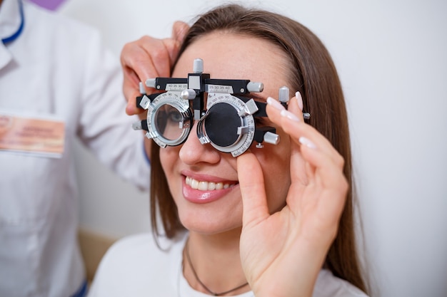 Seleção de óculos para visão para a mulher. A seleção correta de pontos. Salão Ótico. Óptico. Lentes de teste.