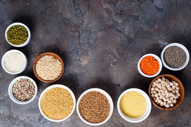 Foto seleção de superalimentos e cereais em taças em fundo cinza de concreto