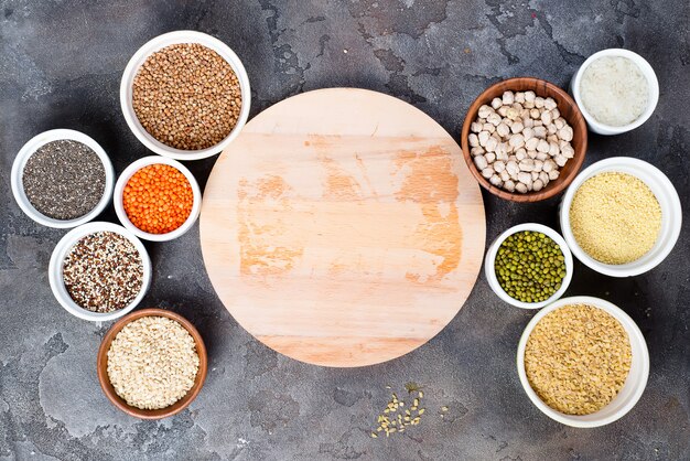 Seleção de superalimentos e cereais em tigelas com placa de madeira para o seu texto