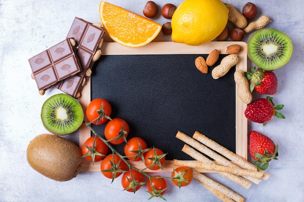 Selección de alimentos para alergias naranja limón cítricos rojo tomate fresa kiwi chocolate nueces pan gluten comida Copia espacio tablero fondo vista superior plano sobre la cabeza