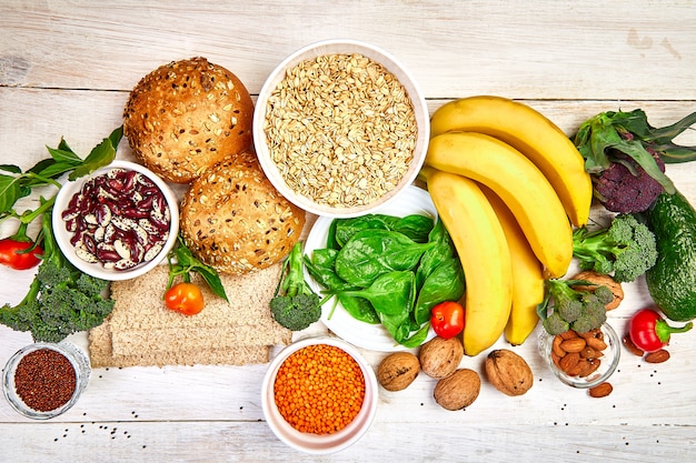 Foto selección de alimentos ricos en fibra sobre fondo blanco de madera