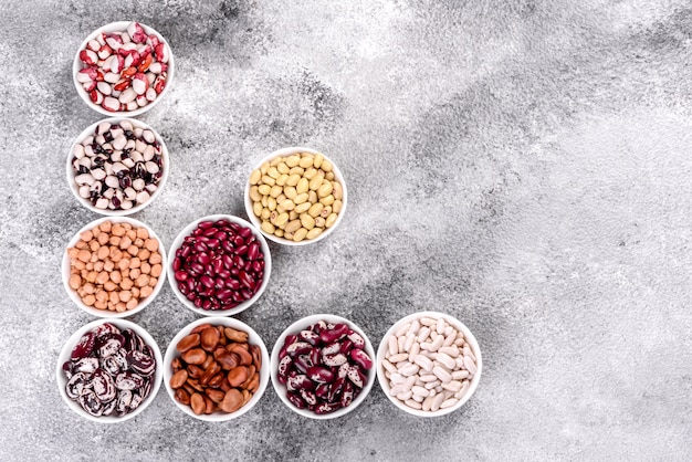 Foto selección de alimentos saludables de legumbres en platos de porcelana blanca.