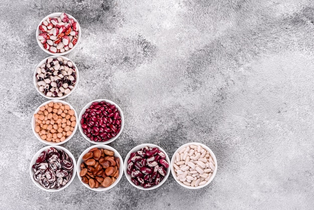 Foto selección de alimentos saludables de legumbres en platos de porcelana blanca.