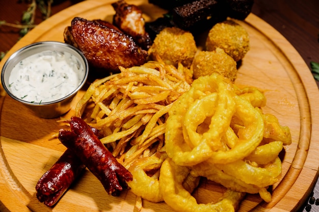 Selección de cervezas y snacks. Patatas fritas, pescado, salchichas de cerveza en la mesa