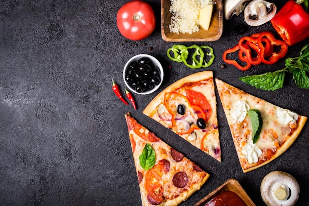 Selección de piezas surtidas de pizza sobre fondo negro e ingredientes. Pizza de pepperoni, vegetariana y mariscos.