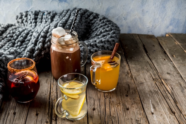 Selección de varias bebidas tradicionales de otoño: chocolate caliente con malvaviscos, té con limón y jengibre