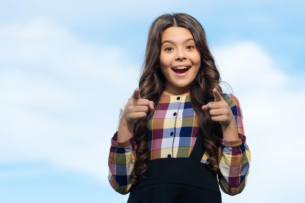 Selecciona Esto. Niño feliz punto índice dedos cielo soleado. Comercialización de productos o servicios de regreso a la escuela. Educación escolar. Señalamiento objetivo. Gesto manual. Apuntando con el dedo para copiar espacio.