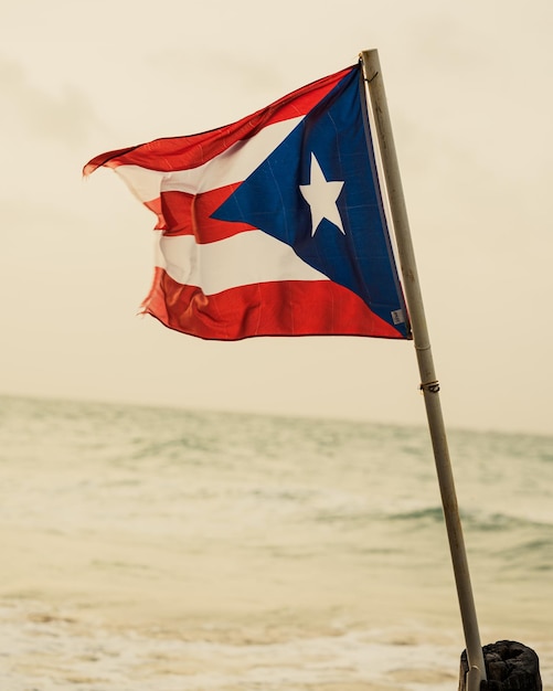 Selectiva de una bandera de Puerto Rico contra el mar en un día sombrío