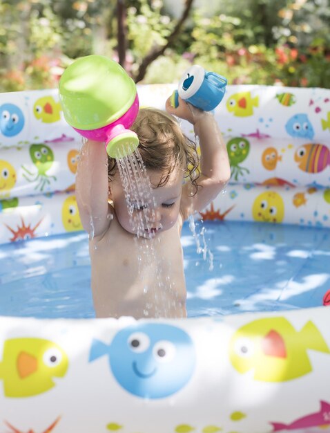 Foto selektive fokusaufnahme eines entzückenden kleinen mädchens, das in einem pool spielt
