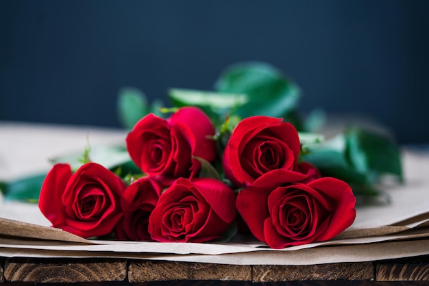 Selektive Fokusaufnahme von roten Rosen auf einem Holztisch