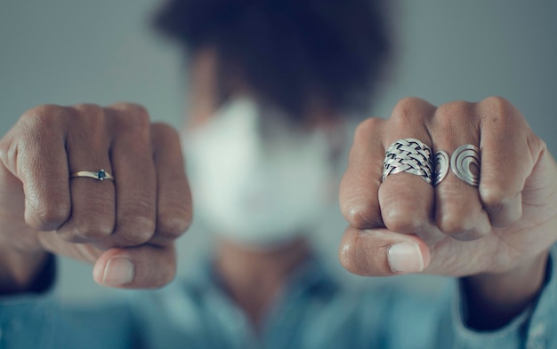 Foto selektiver fokus auf die faust einer schwarzen frau, die eine maske trägt konzept des kampfes gegen das coronavirus