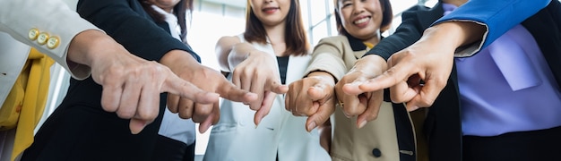 Selektiver Fokus auf die Hände mehrerer Geschäftsfrauen in formellen Anzügen, die während des Geschäftstreffens mit den Fingern in eine Richtung zeigen. Konzept für Geschäftstreffen.