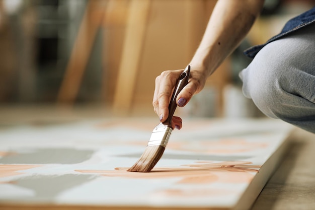 Selektiver Fokus auf die Hand einer jungen kreativen Frau mit Pinsel