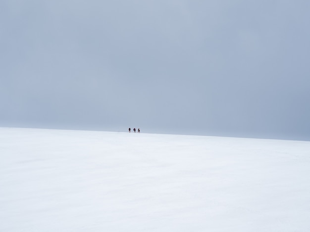 Selektiver Fokus. Bergsteiger kommen auf den schneebedeckten Hügel. Teamwork und Sieg, Teamwork von Menschen unter schwierigen Bedingungen. Schwieriger Aufstieg zum Gipfel des Berges.