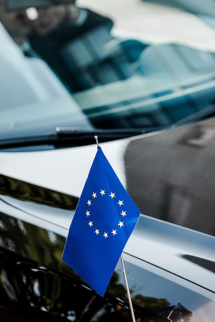 Selektiver Fokus der Flagge der Europäischen Union in der Nähe eines schwarzen Autos