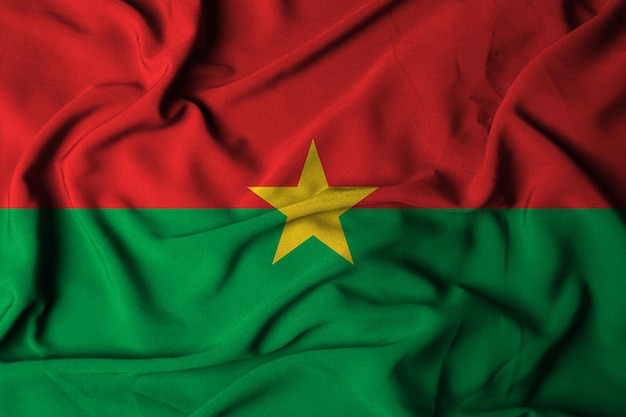 Foto selektiver fokus der flagge von burkina faso mit wehender stoffstruktur. 3d-darstellung