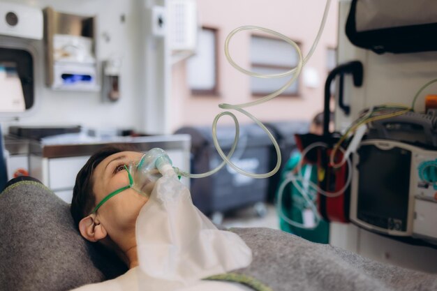 Foto selektiver fokus der sanitäter in medizinischen masken und latexhandschuhen, die während der erste hilfe im krankenwagen sauerstoffmasken tragen