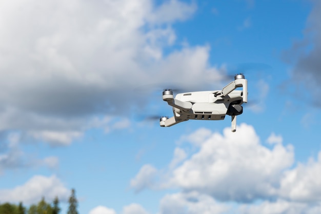 Selektiver Fokus, fliegende Drohne, Quadrocopter, vor dem Hintergrund der sommerlichen Natur und des Grüns