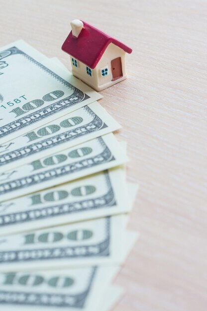 Selektiver Fokus Miniatur kleines Haus mit Dollar-Banknoten Immobilien-Geschäftsinvestitionsdarlehen