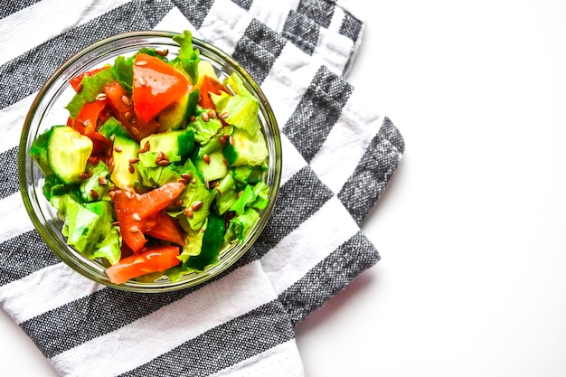 Selektiver Fokus serviert Teller mit frischem Salat aus Tomaten, Gurken, Salatblättern und Leinsamen