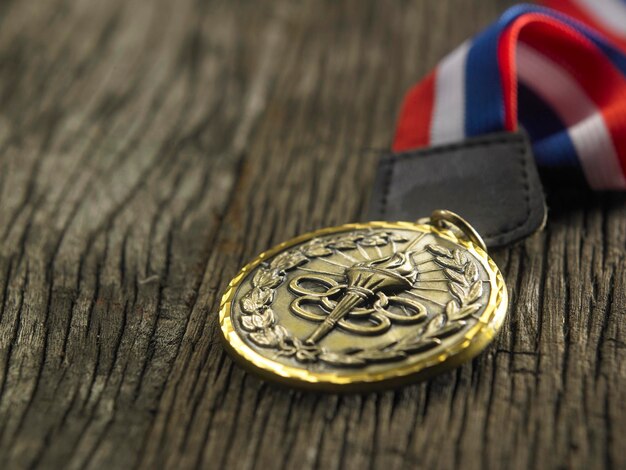 Selektiver Schwerpunkt der Goldmedaille auf dem hölzernen Hintergrund