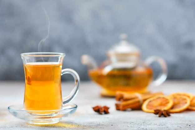 Selektives Fokusfoto von heißem Zitrus-Tee mit Zimt, Orange und Anis