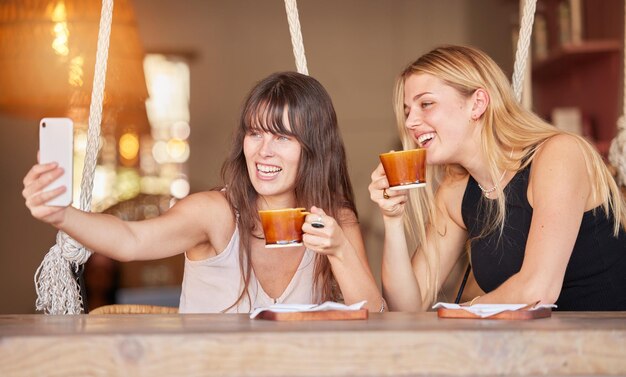 Selfie amigos y café con mujeres en la cafetería para la felicidad en las redes sociales y almuerzo Reunión de verano y tecnología con una chica y un teléfono en la mesa en el restaurante para una sonrisa feliz o comunicación