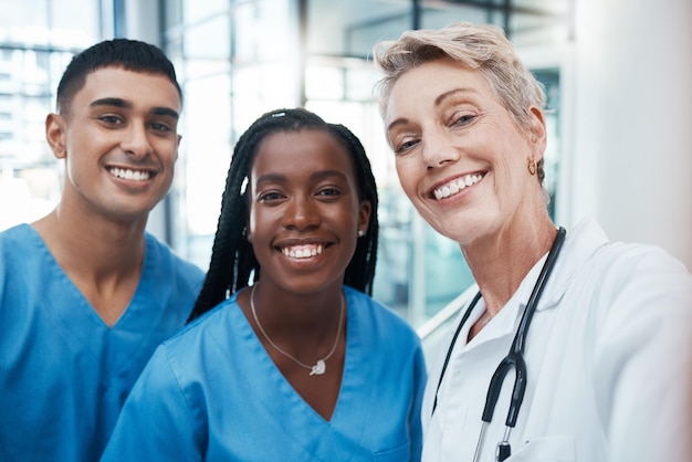 Selfie de atención médica y retrato de un equipo de médicos en colaboración en un hospital o clínica Diversidad de trabajo en equipo y feliz grupo de profesionales médicos tomando una foto mientras trabajan juntos