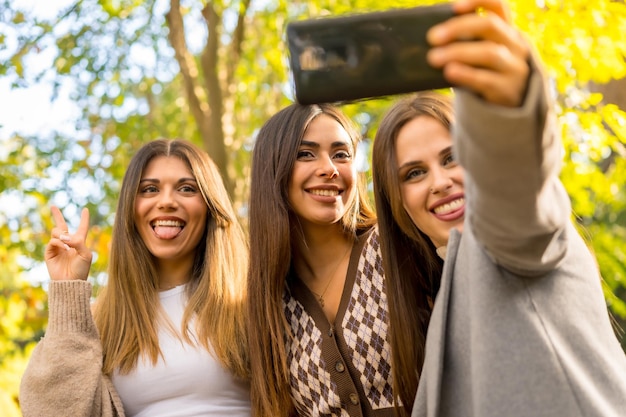 Selfie de amigas sorrindo em um parque no outono, estilo de vida despreocupado no outono