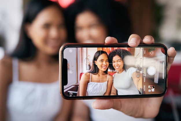 Selfie de amigos de mulher e tela de telefone para postagem de blog de mídia social ou ligação em restaurante Grupo de influenciadores de mulheres negras felizes e imagem de smartphone para aplicativo de rede social ou internet com sorriso