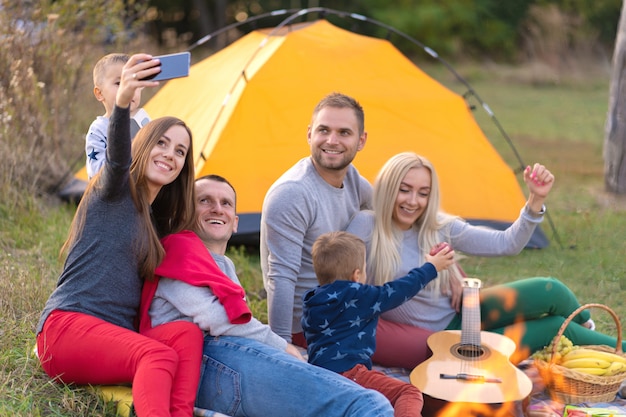 Selfie de amigos na natureza. amigos estão descansando perto do lago. grande companhia divertida. grande família reunida em férias. crianças e pais em um piquenique na floresta de verão.