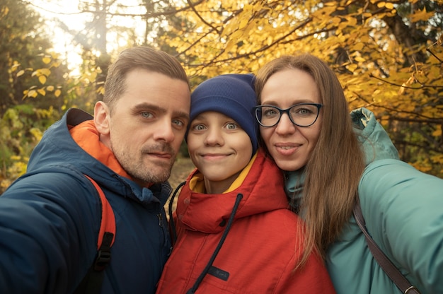 Selfie de família feliz no parque de outono em fundo de natureza de outono