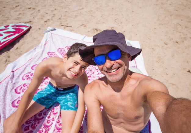 Foto selfie de feliz pai e filho curtindo a praia