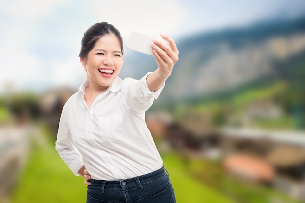 Selfie de mulher asiática com fundo de paisagem natural