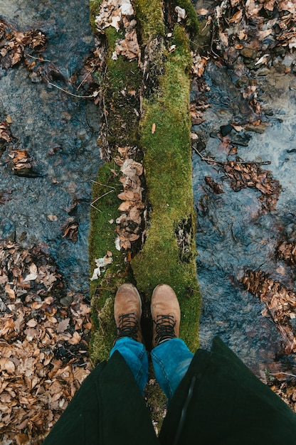 Selfie de pés em botas no outono ou na primavera. Viagem e aventura na floresta