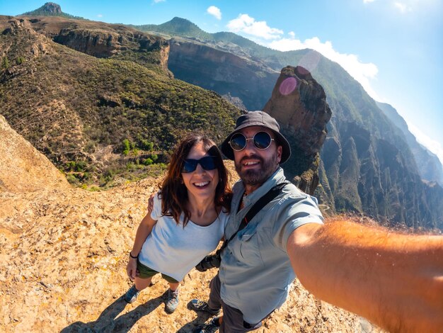 Foto selfie de um casal no ponto de vista de roque palmes, perto de roque nublo, em gran canária, ilhas canárias